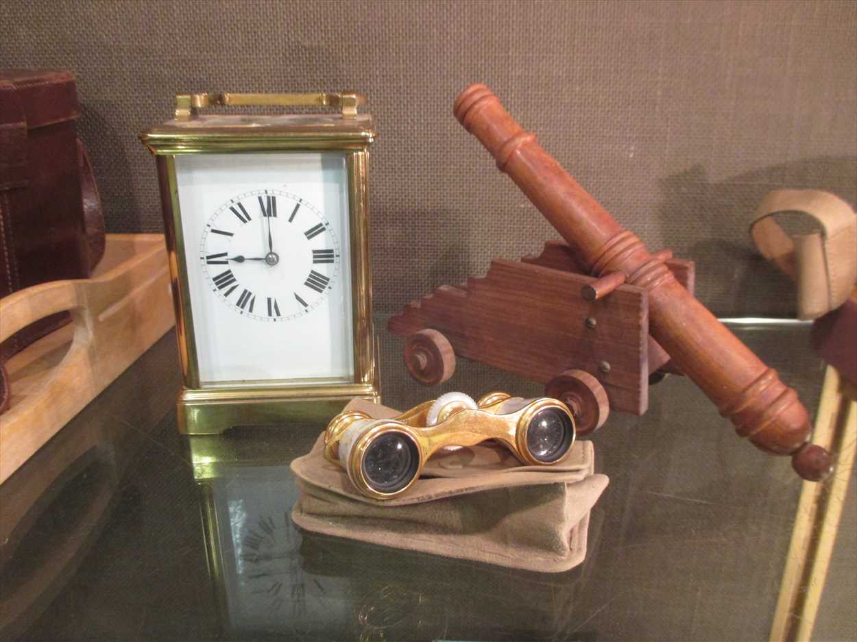 A French carriage timepiece, opera glasses and model canon.