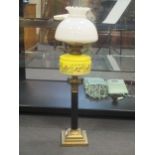 An oil lamp with yellow glass reservoir