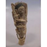 A late 19th century Japanese carved ivory figure of a girl playing a sho and seated on the back of a