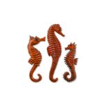 A graduated matched set of three Sanchez & Bayer orange glazed seahorses,