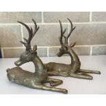A pair of decorative brass recumbent stags,