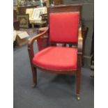 A French Empire carved mahogany dining armchair, with square padded back, down curved reeded arm