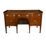 A George III mahogany serpentine sideboard with galleried back,