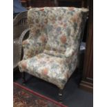 A wingback armchair, upholstered floral pattern tapestry, on turned front legs