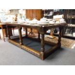 An Victorian oak refectory table, the canted top with a carved border supported by six turned column