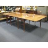 A George III large figured mahogany drop flap dining table in two sections with gate action on