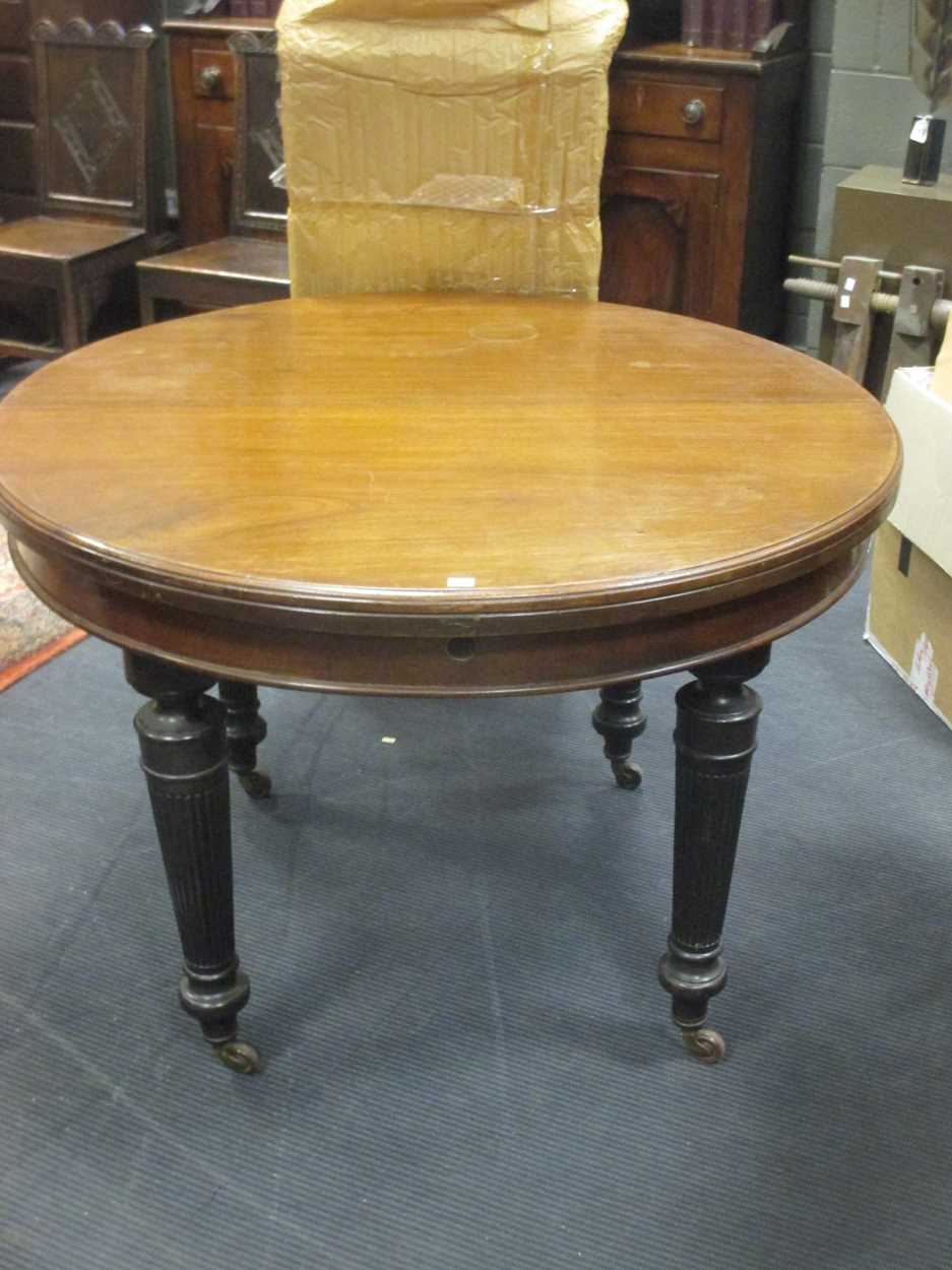 A late 19th century extending dining table with additional leaf