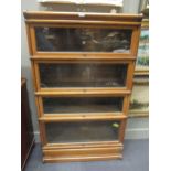 A pair of globe wernicke and co. oak four section book cases, with up and over doors, 146x86x31cm
