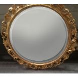 A Florentine carved gilt wood circular wall mirror, with bevelled plate 64cm diameter