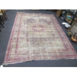 A worn pink ground Persian carpet 374 x 276cm