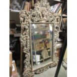 A Baroque style carved gilt wood framed wall mirror, surmounted by a putti and shell cresting