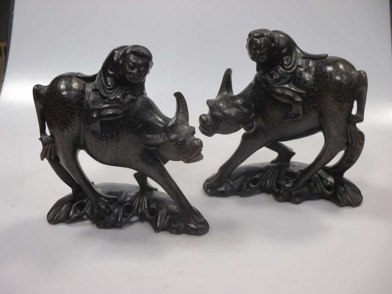 A pair of early 20th century Chinese wire inlaid wood “boy on buffalo” groups,