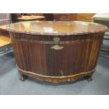 A mid 20th century mahogany coffer, the oval body with linen fold type panels on ball and claw feet,