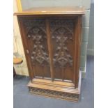 A 19th century oak 'Gothic' carved cabinet, with single door enclosing six drawers, 76cm wide,