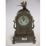 An early 20th century French onyx mantle clock with ormolu mounts and bird crest, 30 cm