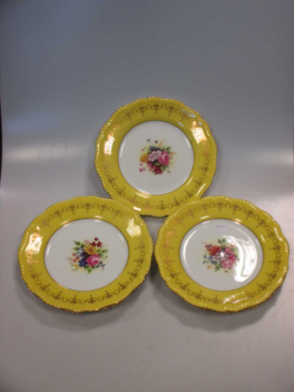 A set of 8 Royal Worcester plates, decorated with central spray of flowers (signed) and yellow