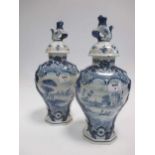 A pair of traditional design Delft painted vase and covers (A/F)