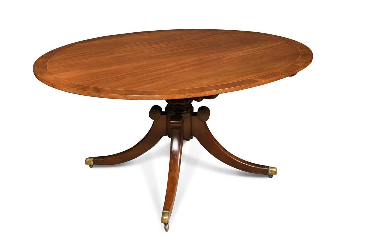 A Regency mahogany oval pedestal dining table, crossbanded border decoration, on four swept legs