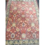 A red ground Persian style rug with blue border 249 x 168cm