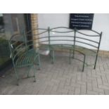 A curved green painted metal garden bench, 178cm wide