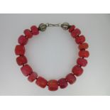 A vintage necklace of large coral beads with two cantaloupe beads,