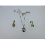 A blue spinel pendant set in gold and a matched pair of earpendants,