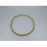 A gold bead necklace stamped '750',