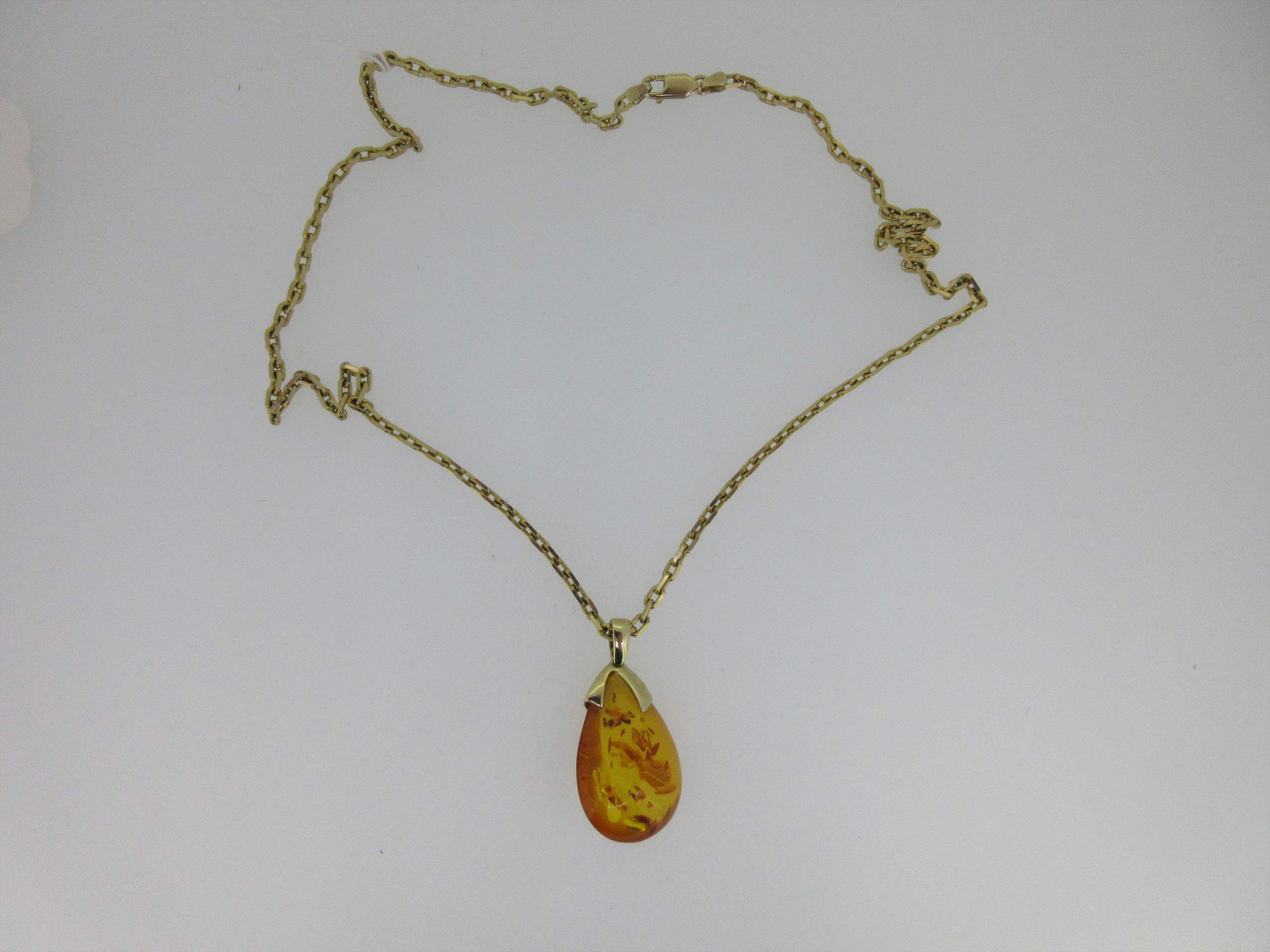 An Italian 9ct gold chain necklace with amber nugget pendant,