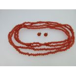 A single row of coral beads and a pair of carved coral earstuds,