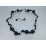 A row of lapis lazuli beads together with a pair of ruby and diamond earpendants,