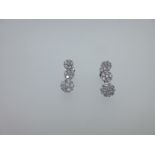 A pair of triple cluster diamond pendant earrings,