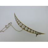 An opal and diamond open crescent brooch,