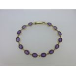 An amethyst line bracelet in hallmarked gold,