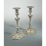 A pair of George III cast silver candlesticks,