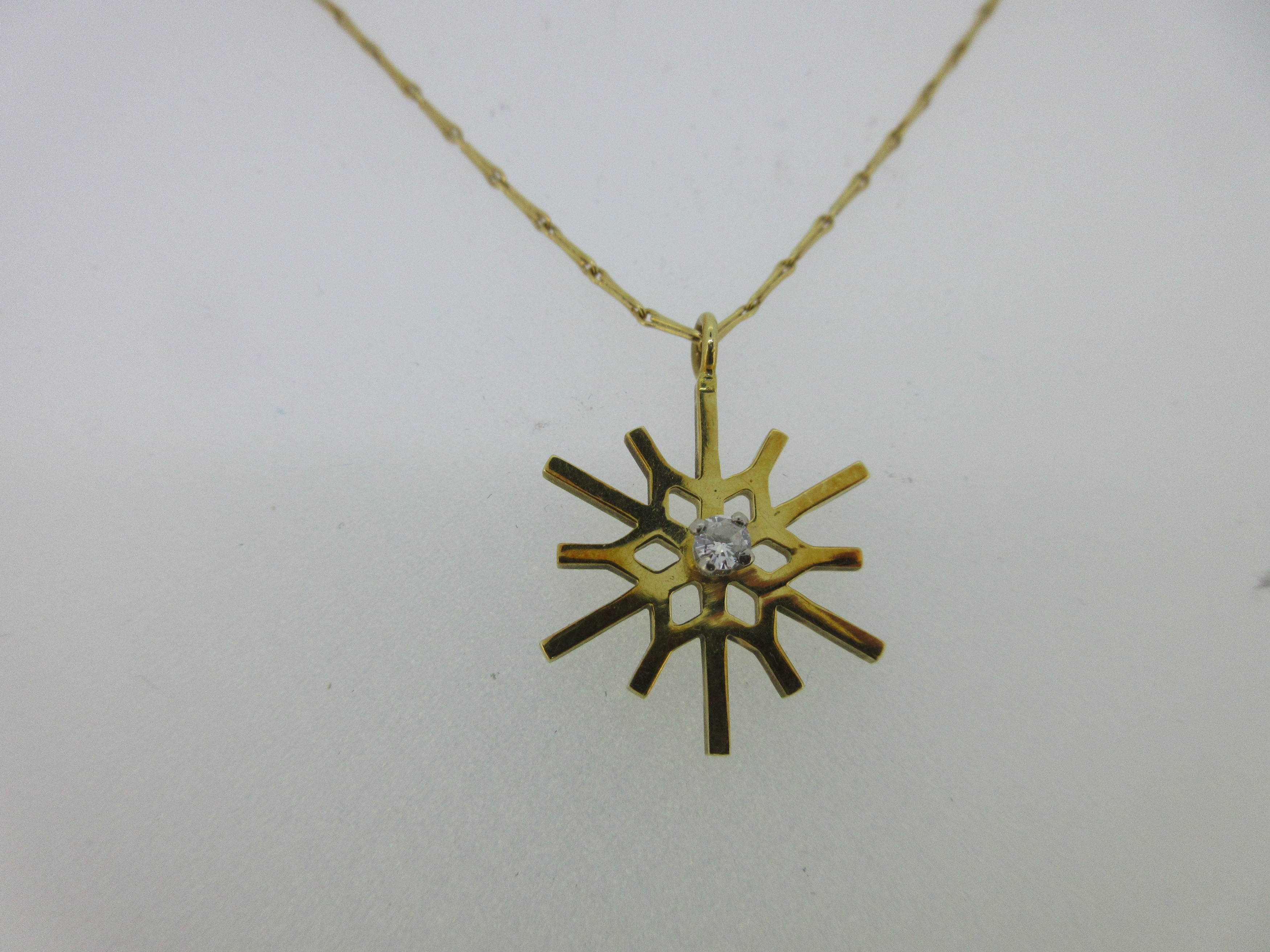 An 18ct gold diamond set snowflake pendant,