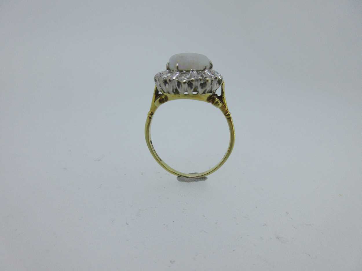 An opal and diamond cluster ring set in hallmarked gold, - Image 3 of 6