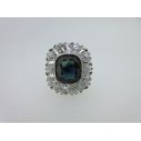 An 18ct gold sapphire and diamond cluster ring, (one diamond with trigon),