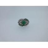 A modern emerald and diamond cluster ring,