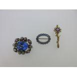 A pale blue sapphire hoop brooch and two other gemset brooches,