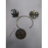 Three white metal brooches, one with enamel and paste decoration, and a bangle (4)