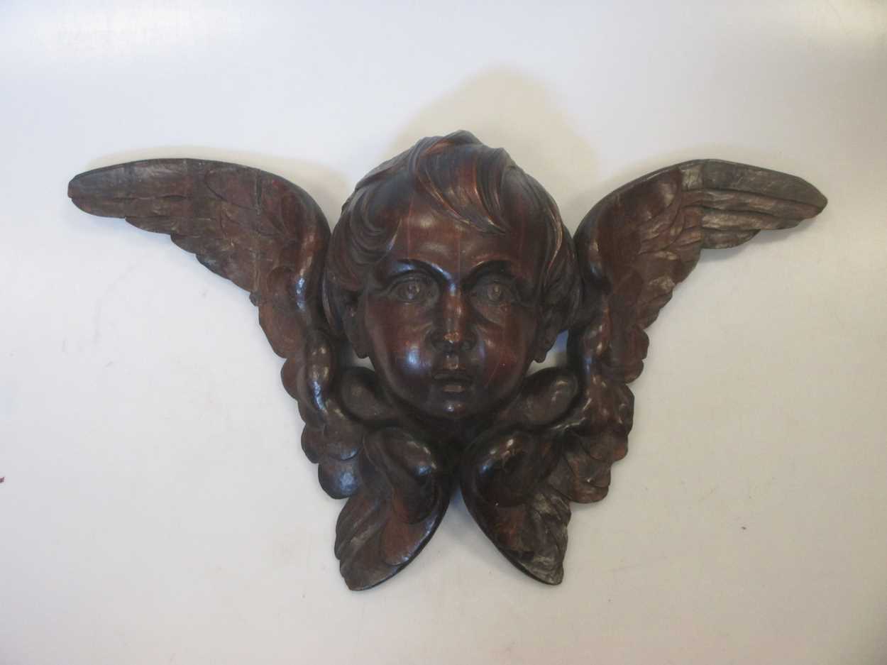 A carved wood cherub head 44cm wide