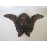 A carved wood cherub head 44cm wide