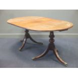 A Regency style mahogany twin pedestal dining table with leaf, 7 chairs and a serpentine front