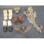 A pair of carved cherubs heads, another carved cherub head, two pine brackets and a pair of