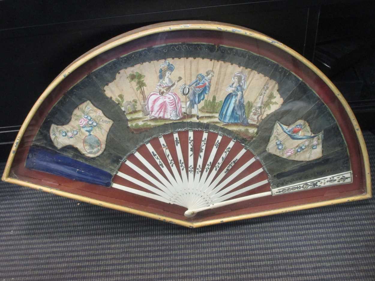 A mid-18th century French paper and bone fan, the central cartouche featuring three figures in a