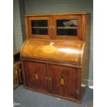 An early 19th century mahogany and inlaid cylinder bureau, the fall section housing a fitted