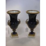A pair of French Empire style gilt metal mounted blue vases, with rams head handles on square