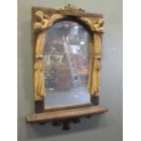 A carved mirror frame made up from constituent parts, with a pair of figures supporting draperies