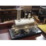 A silver coloured novelty locomotive shape urn on stand, 40cm high including stand