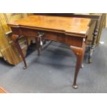 A Georgian red walnut or mahogany fold over top games table on cabriole supportsm 88cm wide